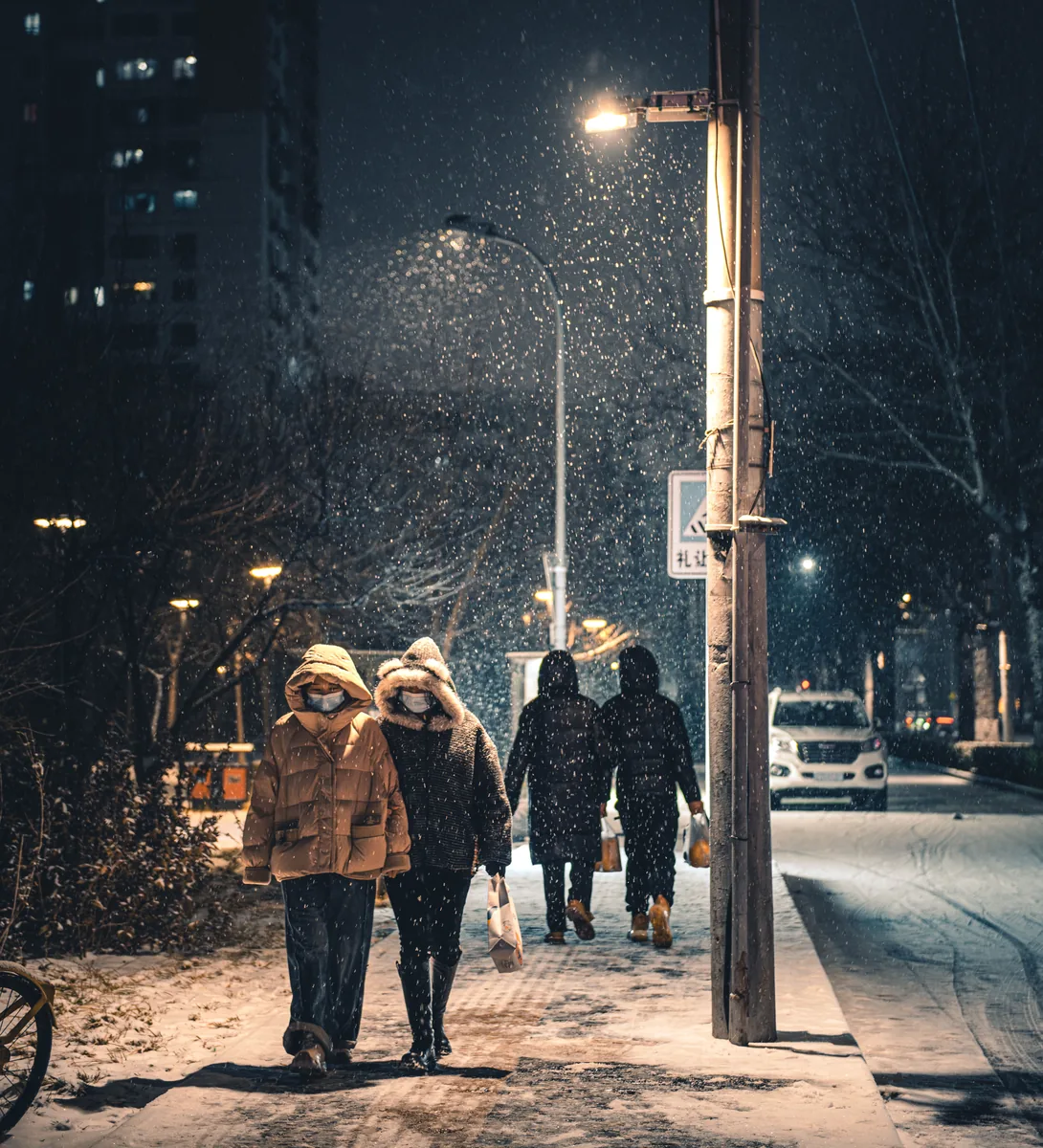 路灯下走过夜色街道的人们