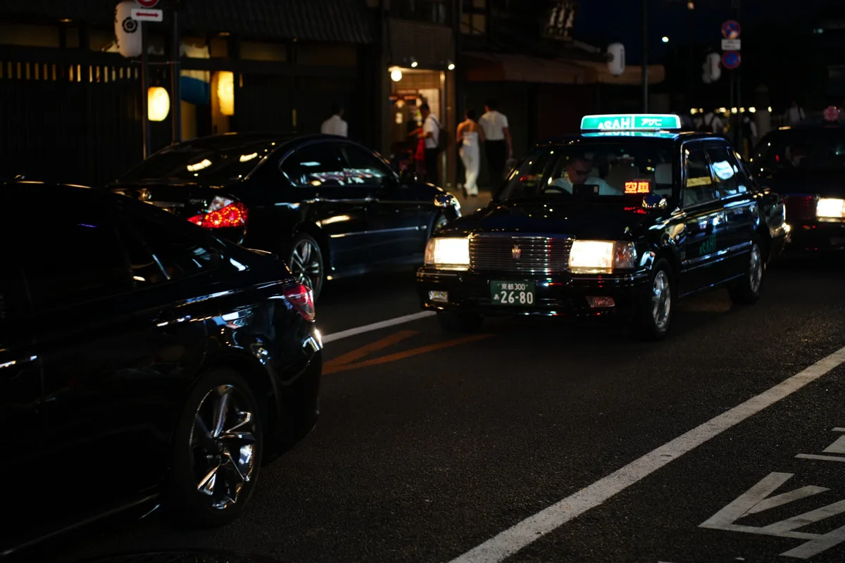 夜间街道上出租车与汽车停在暖色店铺前