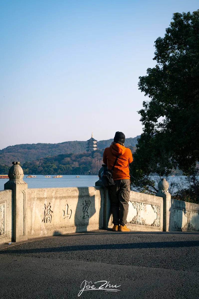 石栏旁眺望湖面的人