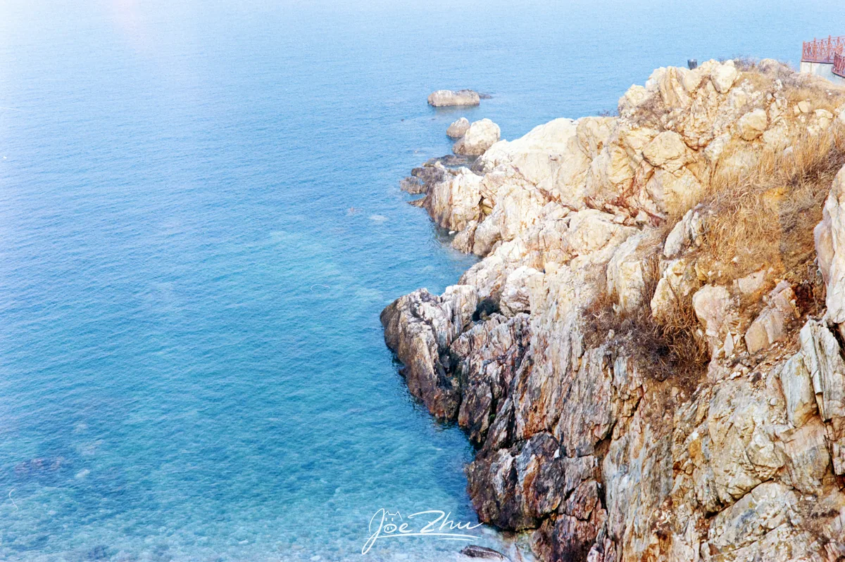 清澈蓝海旁的浅色岩岸