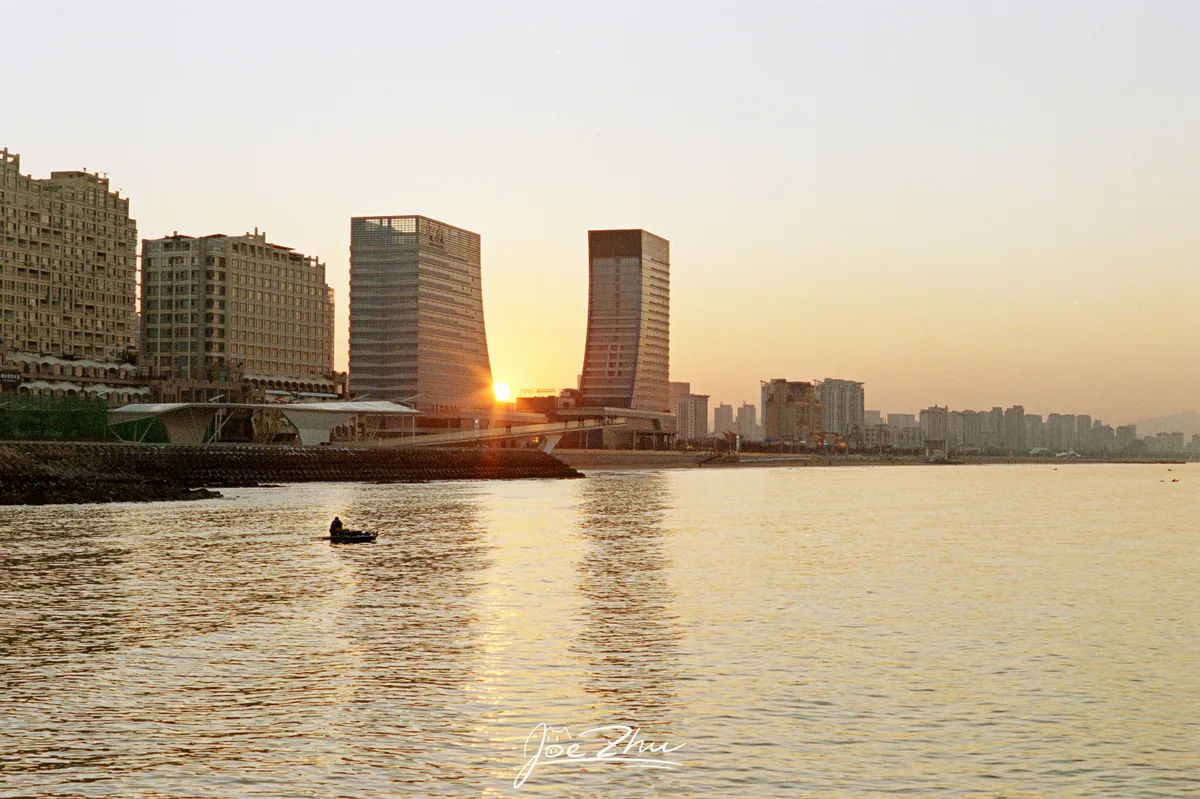 落日在水岸高楼之间下沉