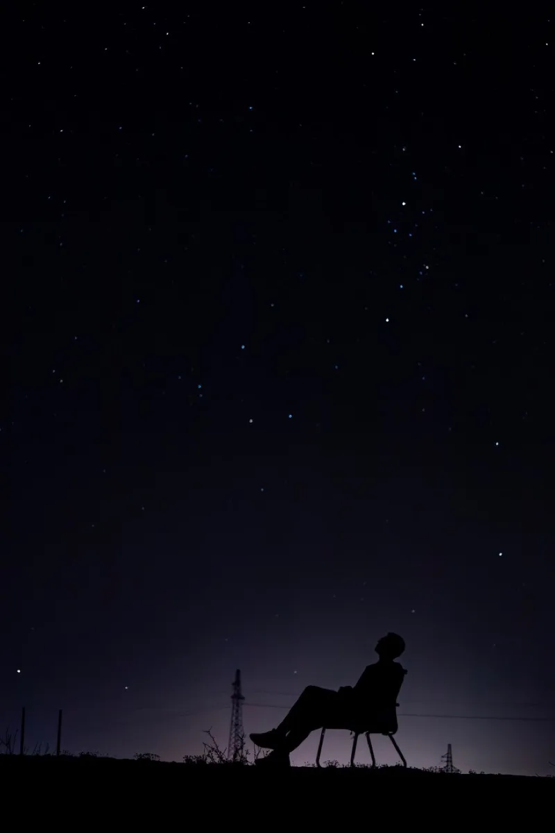 夜空下坐在椅子上的人物剪影仰望繁星