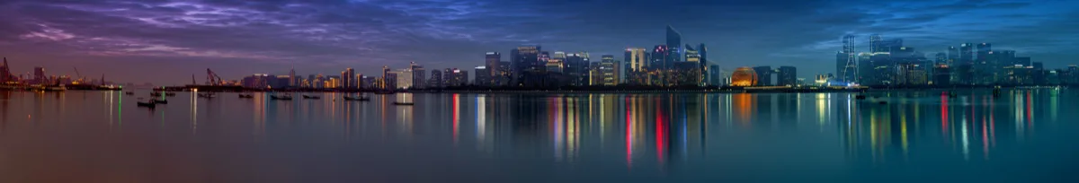 暮色城市与水面灯光展开成狭长全景