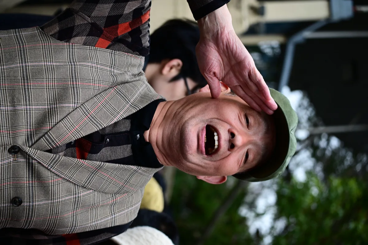 一名女子在人群中仰头大笑并举手致意