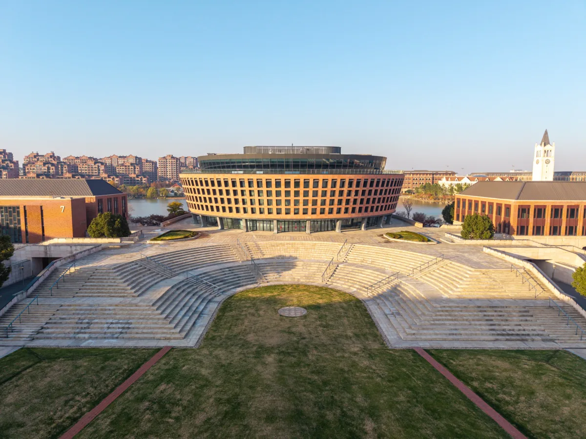 圆形图书馆居中，钟楼与湖岸建筑分列两侧