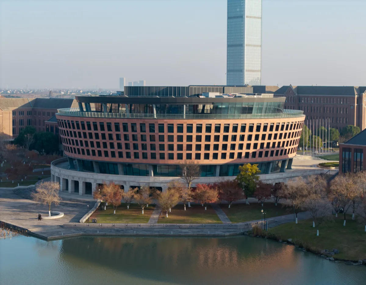 湖边圆形图书馆与后方高塔的航拍近景