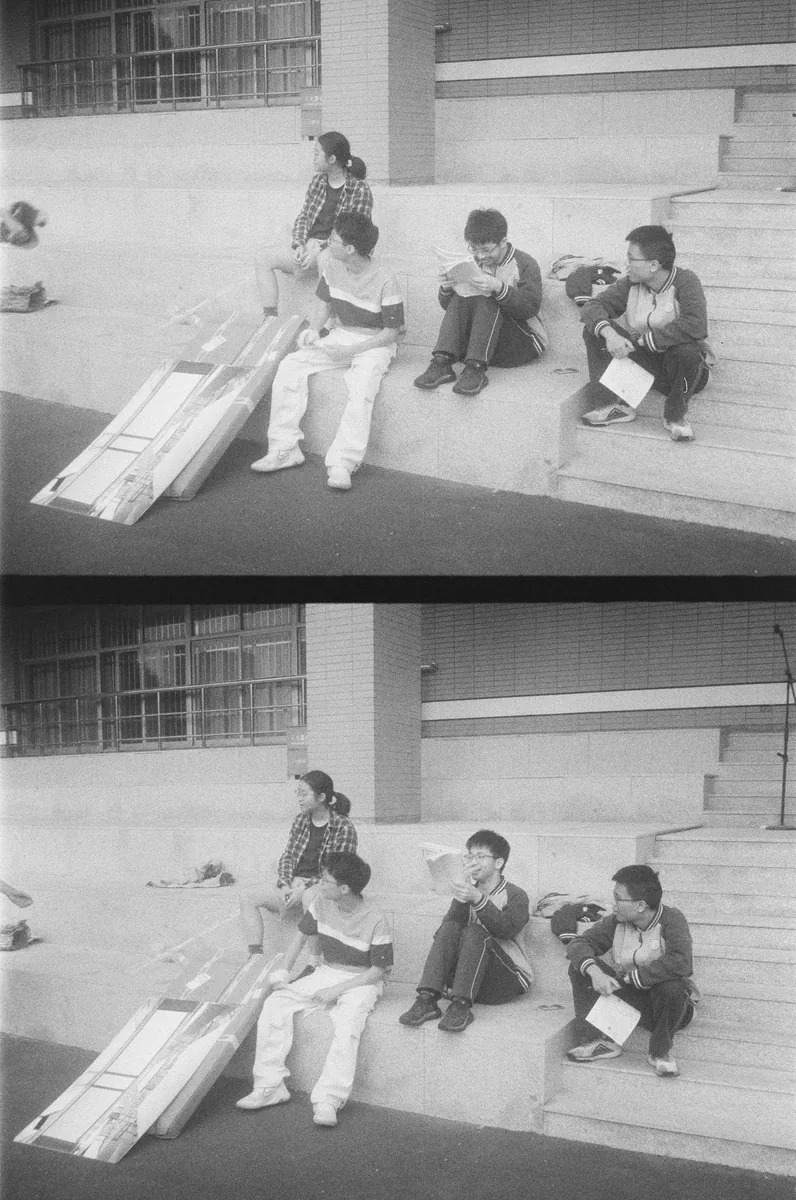 上下两幅画面中学生并坐在台阶上
